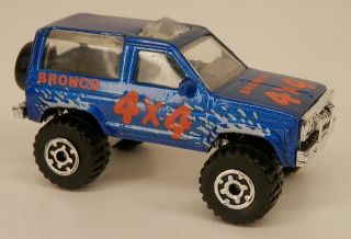 Matchbox 1984 - 1988 Ford Bronco Ii 4x4 Blue W/white Splashes Suv 1/57 Scale